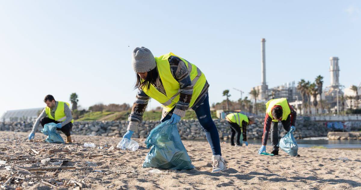 People in high vis jackets doing a beach cleanup