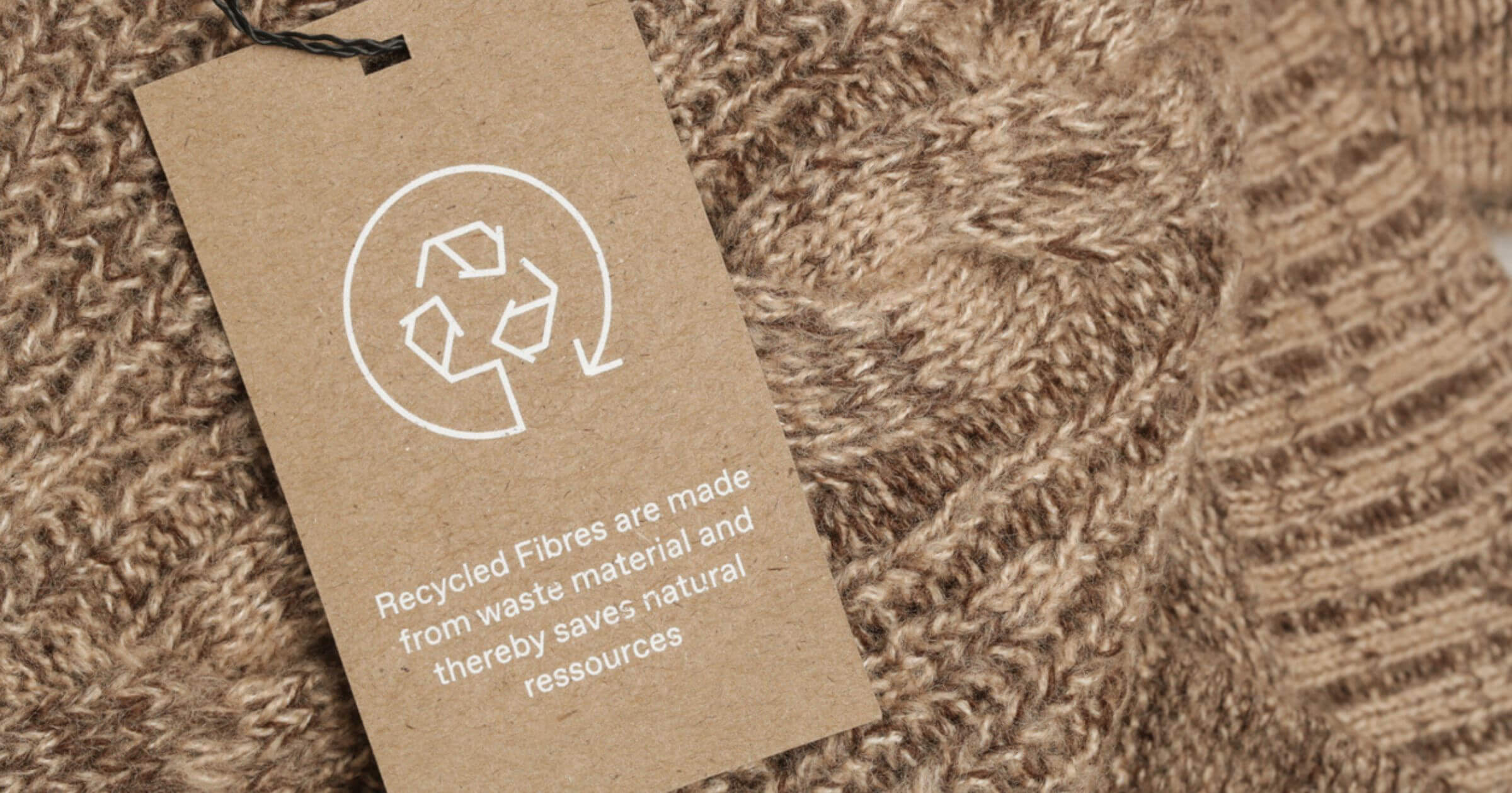 A close up of a clothes label focused on recycling the materials