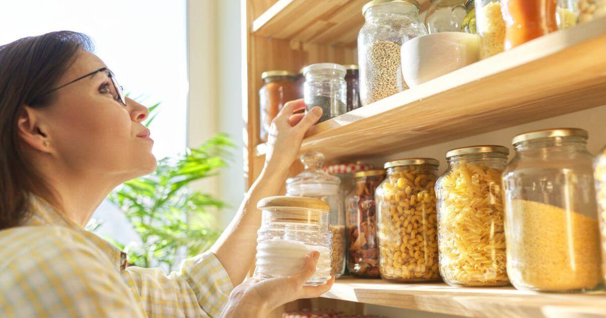 Someone looking up to a shelve with lots of glass containers on it