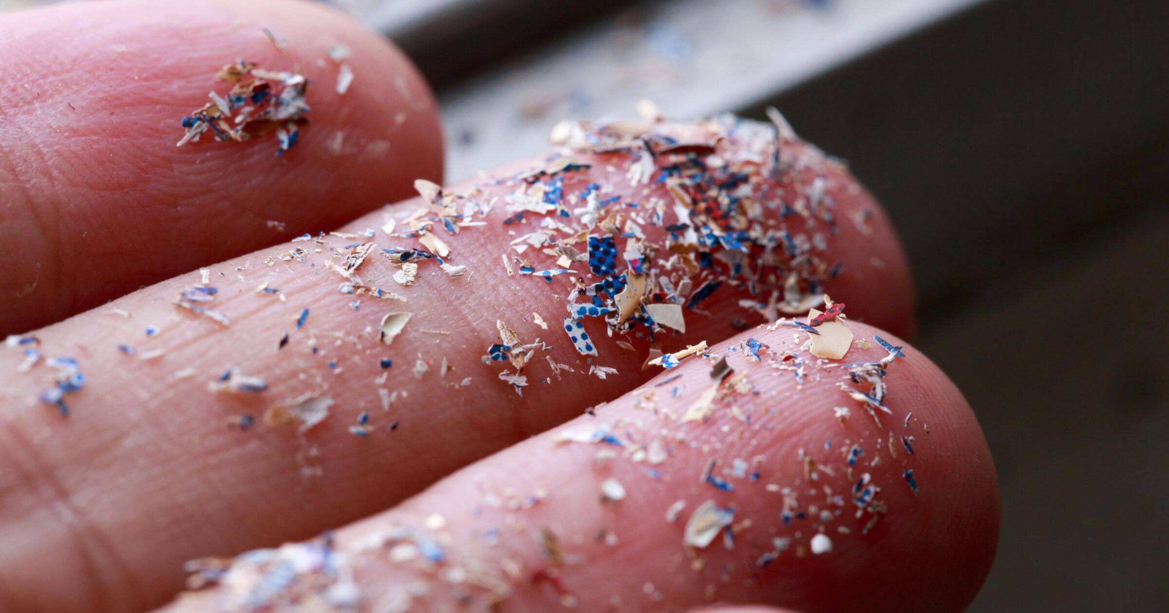 A close-up of lots of microplastics on the end of someones fingertips