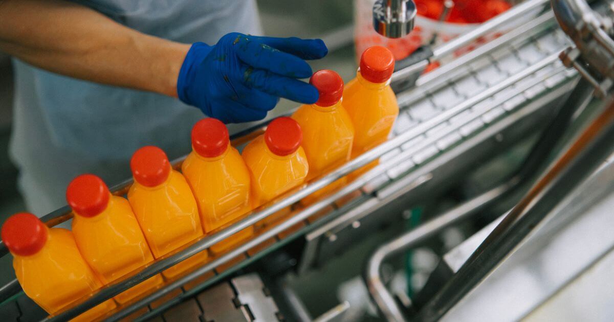 A bird's eye view of orange plastic bottles on a production line