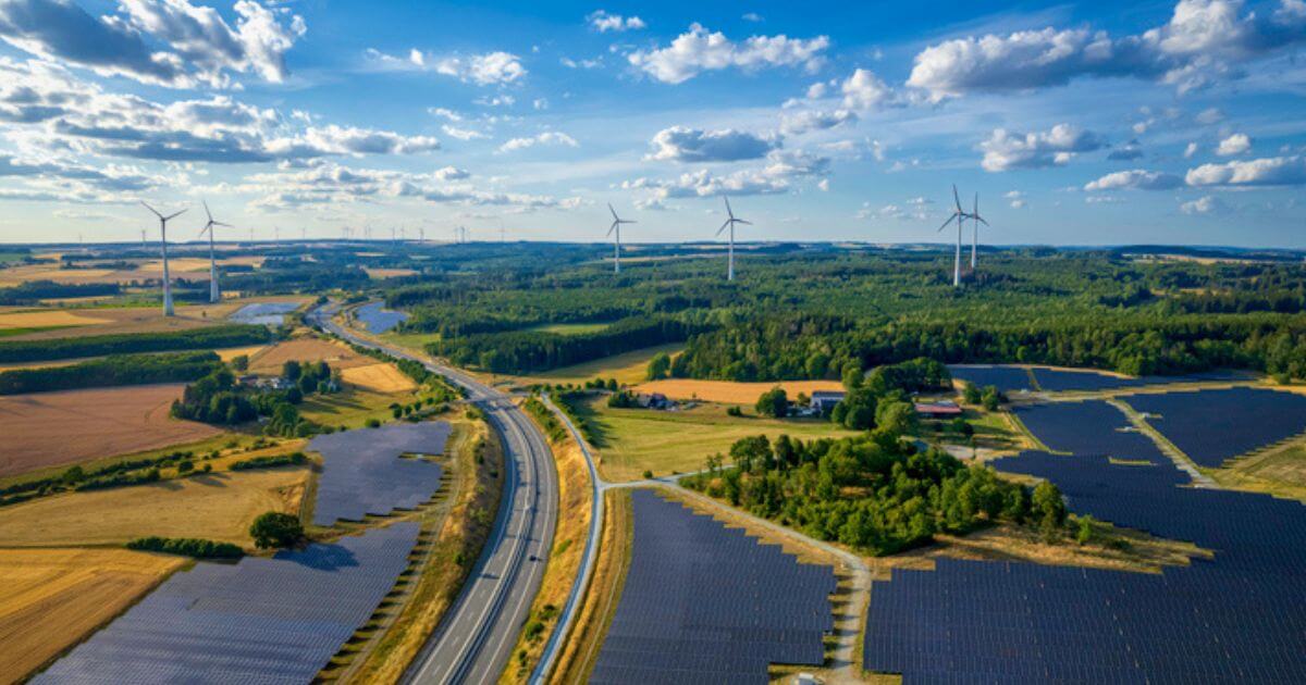 A view of solar farms nad wind turbines on a sunny day