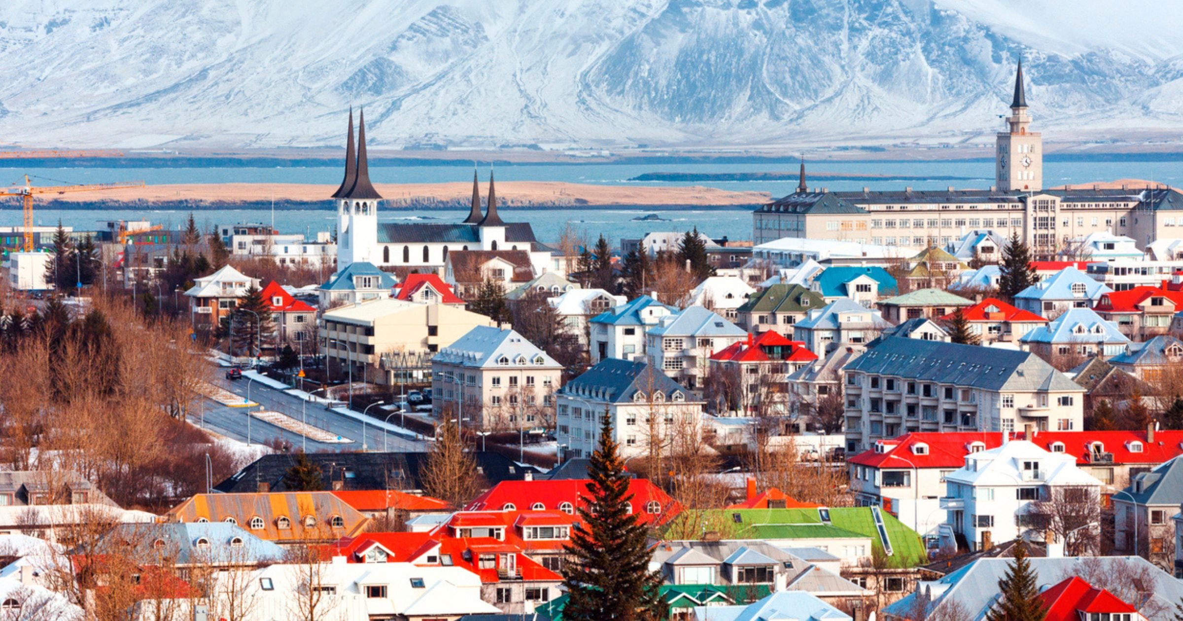 Rows of red roofs in Reykjavik city with mountains in the background